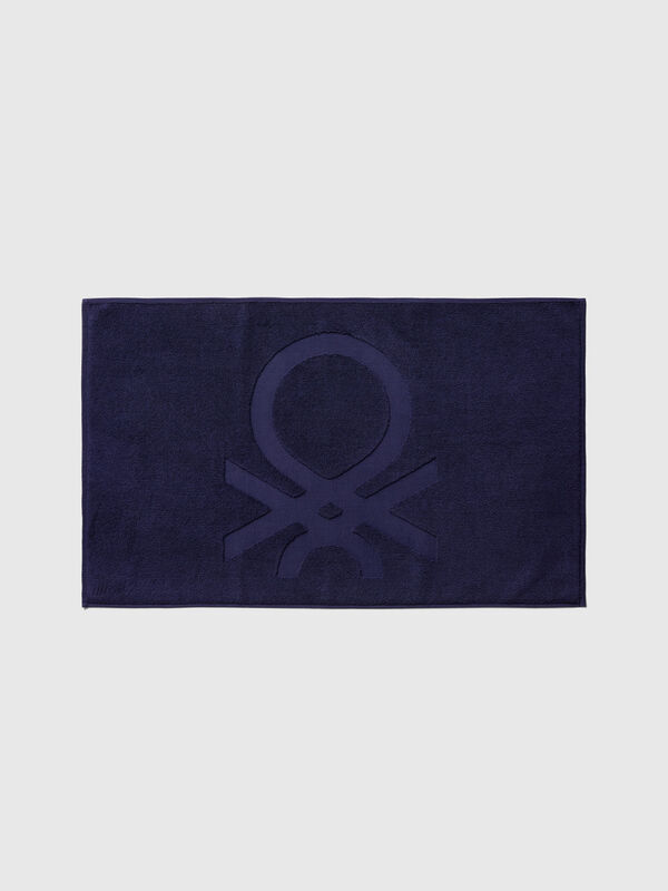 Dark blue bathroom rug with logo